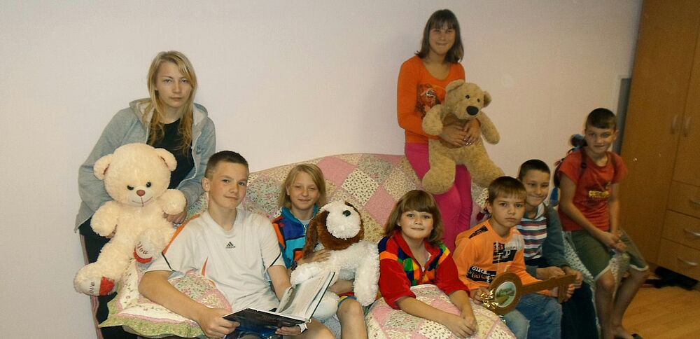 Eight children share the apartment and a family life.